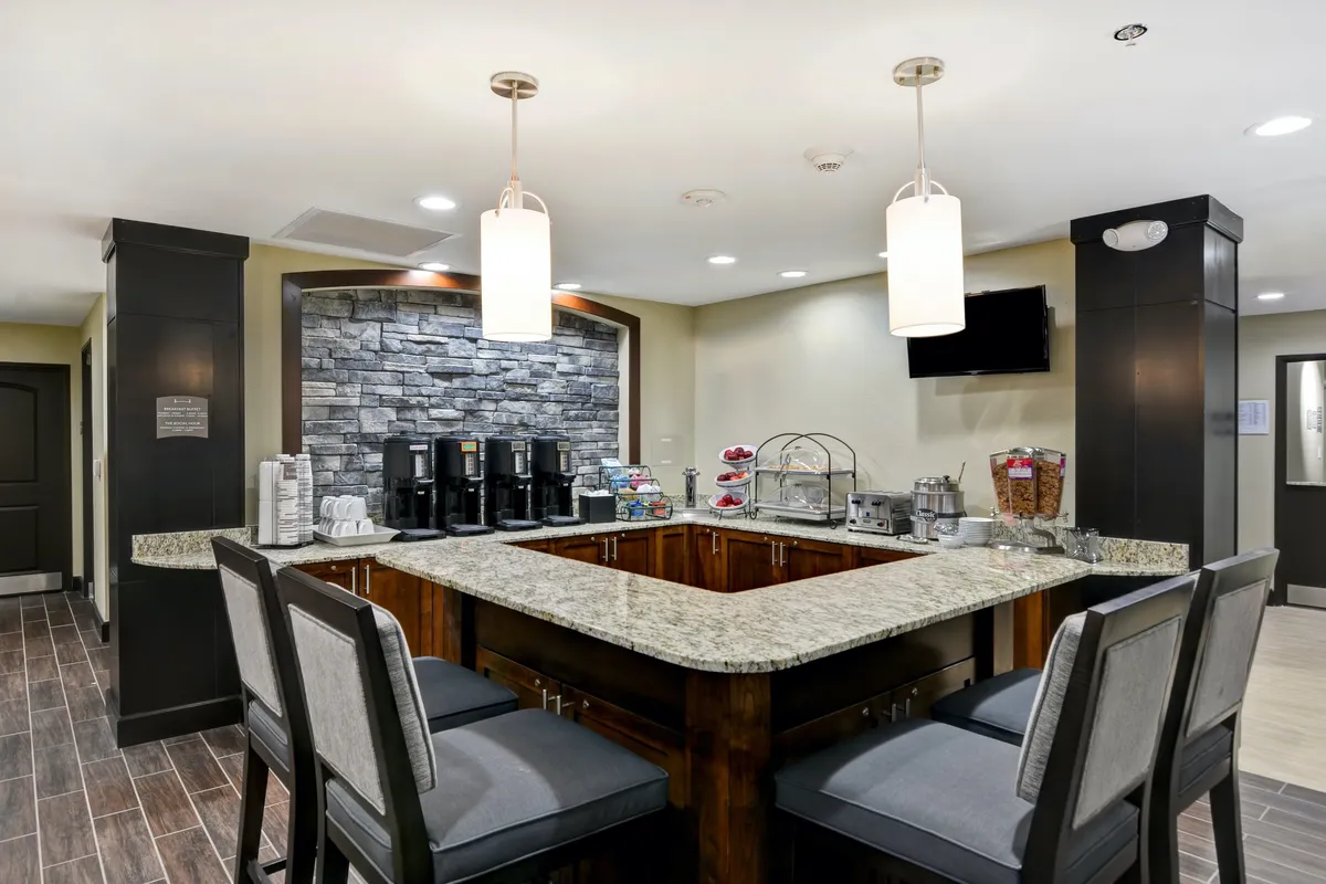 The image presents a granite-topped coffee and snack station, featuring coffee machines and a snack display. This communal area offers guests a pleasant spot to begin their day or recharge between outings, ideal for couples planning adventures in Nashville and Mt. Juliet.